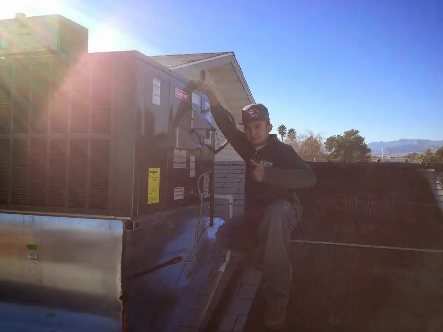 HVAC technician performing Air Duct Repair on a rooftop unit in Fruitland